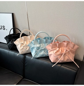 Vue détaillée de sacs à main à volants avec nœuds en noir, crème, bleu clair et rose