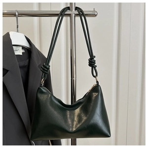 Détail du sac hobo vert foncé avec bandoulière nouée et finitions métalliques dorées