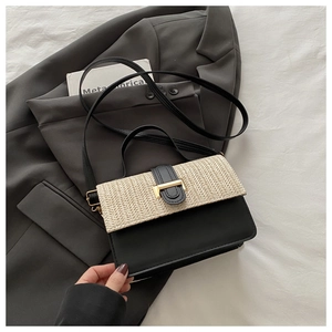 Detail of woven straw flap and black leather splicing on crossbody bag with gold lock