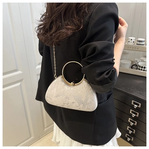 Detail of silver floral jacquard evening bag with gold ring handle and chain strap