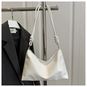 Détail du sac hobo blanc minimaliste avec bandoulière nouée et texture en cuir mat de qualité