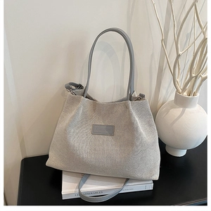 Detail of the woven canvas tote bag with FASHION label on a minimalist desk setting