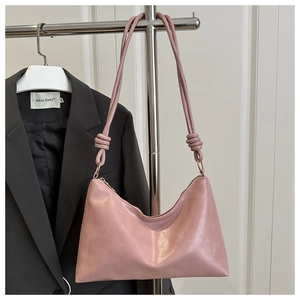 Détail du sac hobo rose clair avec bandoulière nouée et fermeture éclair en métal élégante