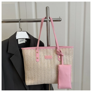 Detail of woven straw tote bag with pink leather strap and small matching zipper pouch
