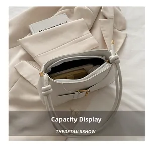 Internal view of cream leather shoulder bag showing spacious storage and golden buckle