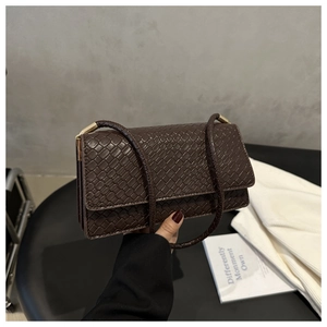 Close-up of the woven texture on this retro brown crossbody bag with a slim strap