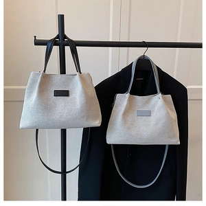 Close-up of glittery woven tote bags in silver-grey with premium fashion labels