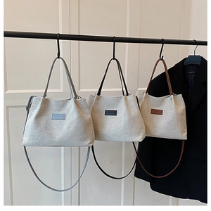 Three textured canvas tote bags with colored straps and fashion labels for commute