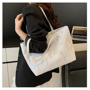 Détails du sac cabas blanc avec broderies ondulées colorées et texture gaufrée chic