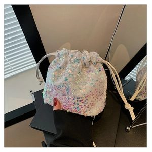 Détail macro des paillettes blanches irisées sur le sac seau à cordon avec reflets colorés