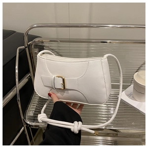 Detail of white leather shoulder bag with gold square buckle and stylish knotted strap