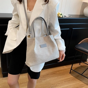 Large beige canvas tote bag with gray leather handles and fashion label for casual wear
