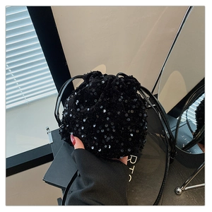 Détail du sac seau à paillettes noires montrant la texture brillante et le style soirée