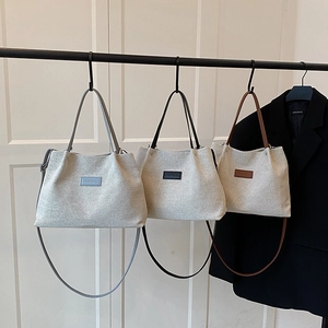 Three minimalist canvas tote bags in blue, black and brown colors for daily commuting