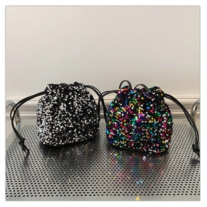 Détail de sacs seaux à paillettes avec fermeture à cordon en argent et multicolore