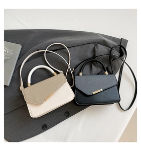 Detail view of stylish dual-texture tote bags with golden hardware and leather strap