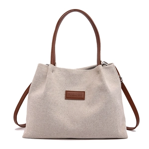 Minimalist beige canvas tote bag with brown leather handles and a FASHION leather patch