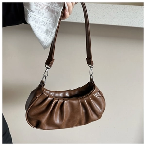 Détail de la texture plissée en cuir PU marron et boucle en métal argenté sur le sac à bandoulière