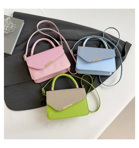 Close-up of stylish contrast color handbags with metal buckle and textured leather detail
