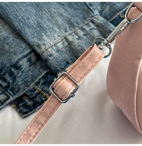 Detail of adjustable pale pink shoulder strap with silver metal buckle and lobster clasp