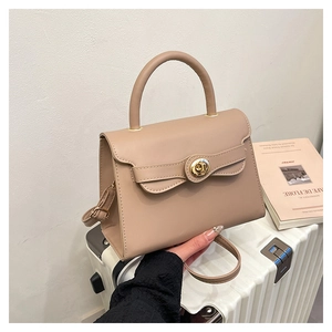 Detail of minimalist beige faux leather handbag with gold twist lock for office daily commute