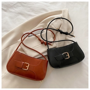 Detail of vintage shoulder bags in black and brown leather with knotted strap accents