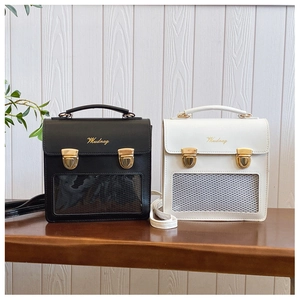 Detail of square ita bags in black and white with clear display windows and metal buckle
