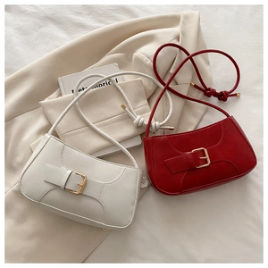Detail of red and white minimalist crescent shoulder bags with gold buckles and matte finish