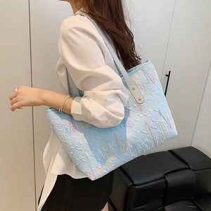 Grand sac cabas bleu clair avec broderies de lettres et coutures ondulées élégantes