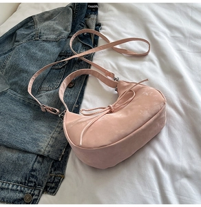 Pink velvet hobo bag featuring a decorative ribbon bow and adjustable crossbody strap
