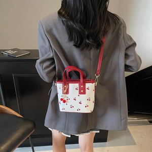 Fashionable white cherry print bucket bag with red handles and cute cherry charm