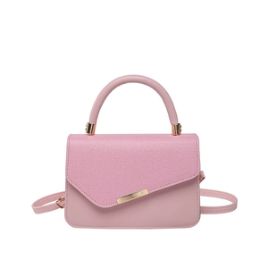Pink PU leather handbag with diagonal texture flap and gold hardware on white background