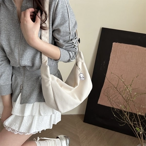 Minimalistische beige Waffel-Sichel-Tasche mit verstellbarem Gurt und Plüsch-Anhänger