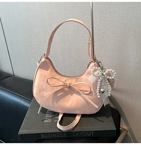 Gros plan détaillé du sac croissant rose avec nœud délicat et accents de perles