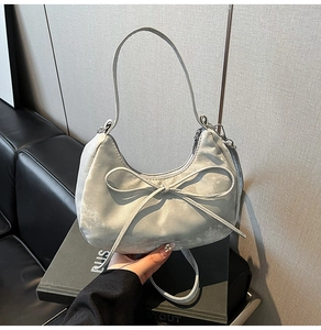 Détail du sac à main croissant en velours argenté avec grand nœud élégant