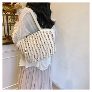 Detail view of woven cotton shoulder bag with decorative tassel and wooden beads