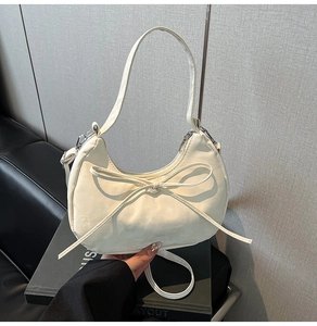 Vue détaillée du sac hobo blanc crème avec nœud en similicuir et fermeture éclair argent