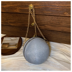 Macro view of silver glitter spherical evening bag with elegant gold chain and metal clasp
