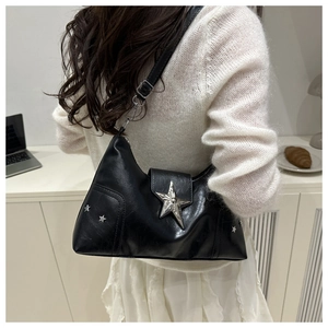 Détail du sac croissant noir avec étoiles argentées porté avec une tenue décontractée