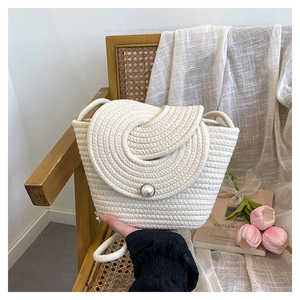 Chic cream white woven bucket bag with pearl closure and stylish spiral texture details