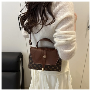 Detail view of vintage-style crossbody bag with geometric pattern and gold ring lock