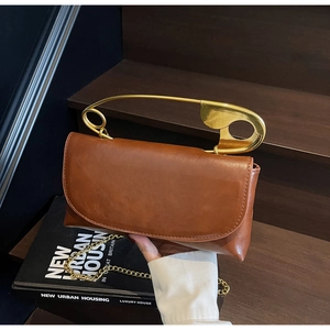 Détail du sac en cuir marron avec grande poignée épingle dorée et chaîne élégante