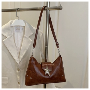 Détail du sac à bandoulière marron vintage avec grand clou en étoile argentée et forme lune