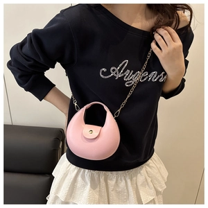 Mini sac demi-lune rose avec bandoulière chaîne dorée porté par un mannequin