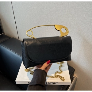 Détail du sac à bandoulière noir avec poignée épingle de sûreté dorée et chaîne