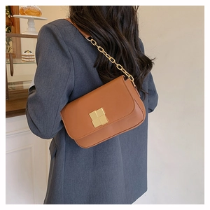Caramel leather flap bag with gold square cross buckle shown on model's shoulder