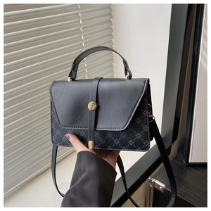 Detail of minimalist leather crossbody bag with geometric pattern and gold clasp hardware