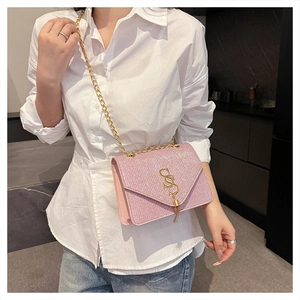 Pink sequin crossbody bag with gold SSS logo and hanging tassel detail macro view