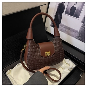 Detail of dark brown crescent bag with woven leather texture in luxury gift box