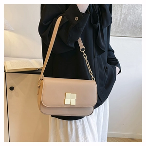 Chic beige crossbody bag with gold chain strap and square buckle on a model